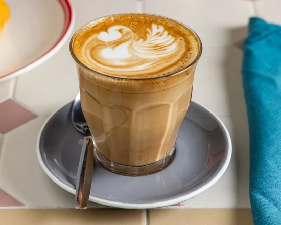 A flat white and long black on the table at Zee's Cafe
